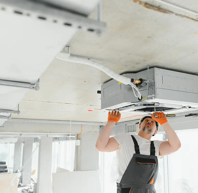 HVAC technician installing ceiling unit