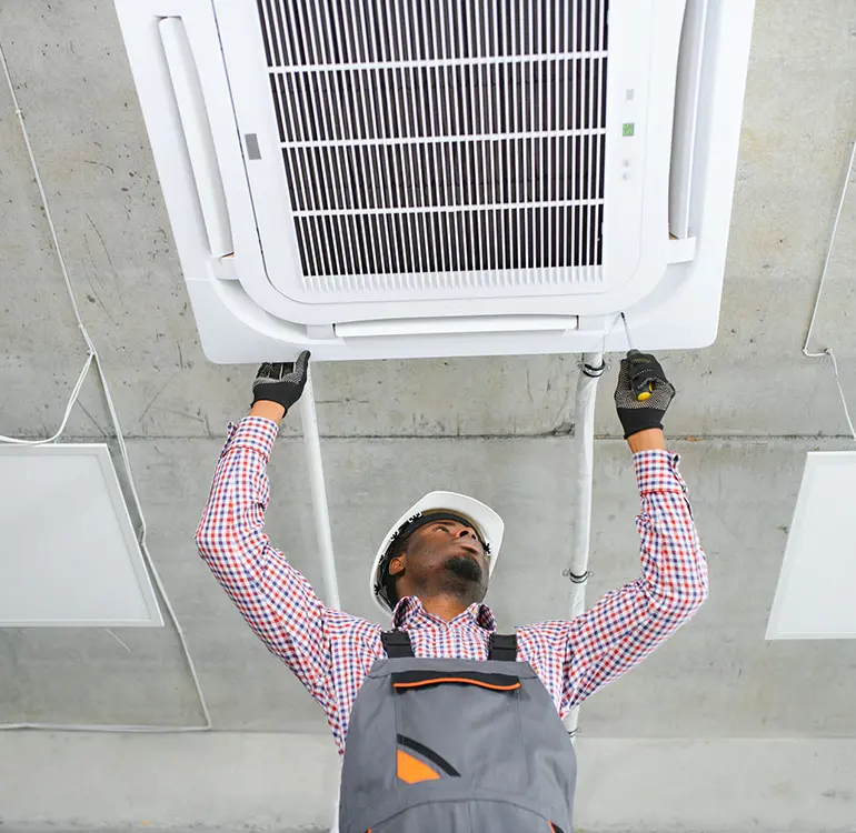 Technician installing ceiling air conditioner