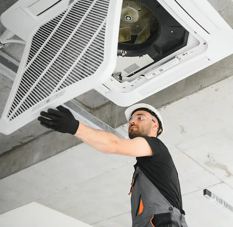 Technician installing ceiling air conditioning