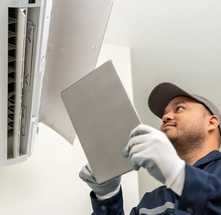 HVAC technician servicing air conditioner