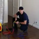 Man using air duct inspection equipment indoors