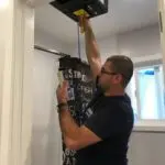 Man inspecting airflow in bathroom